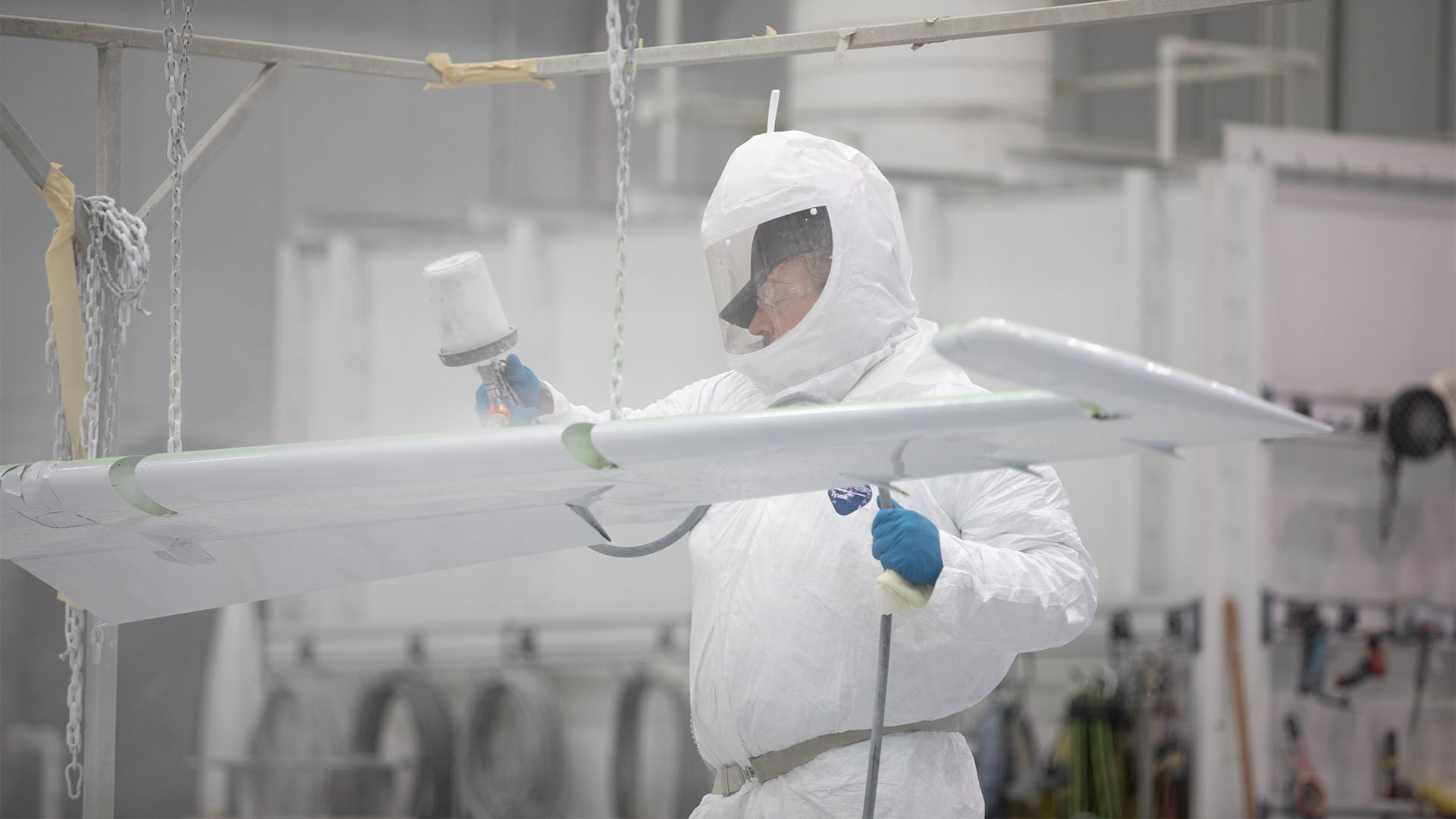 Paint technician working on aircraft wing.